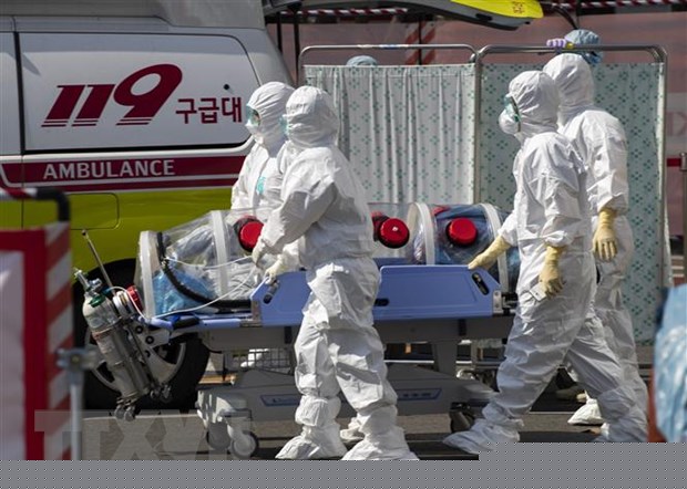 Nhân viên y tế chuyển bệnh nhân nhiễm COVID-19 tới bệnh viện ở Daegu, Hàn Quốc. (Ảnh: THX/TTXVN)