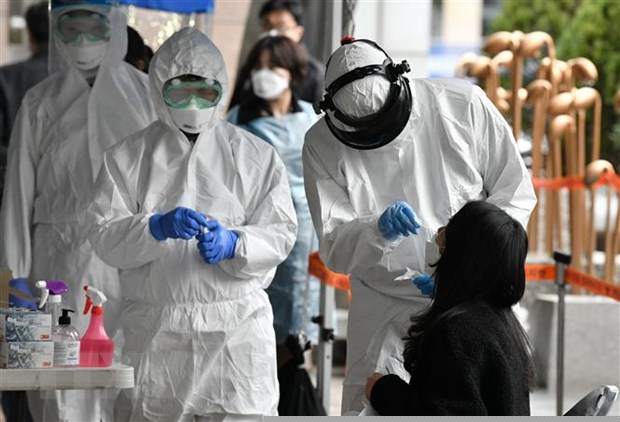 Nhân viên y tế Hàn Quốc lấy mẫu bệnh phẩm của các nhân viên bị nghi nhiễm COVID-19 tại một tòa nhà ở Seoul, nơi phát hiện 46 ca dương tính với virus SARS-CoV-2, ngày 10/3/2020. (Ảnh: AFP/TTXVN)