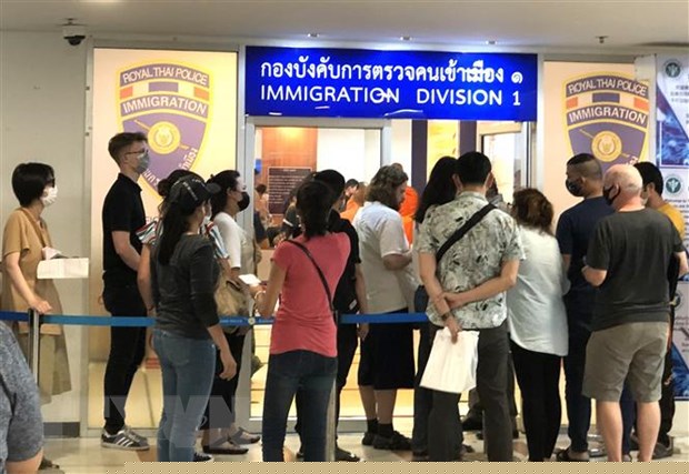 Nhiều người nước ngoài xếp hàng bên ngoài văn phòng Cục Di trú Thái Lan ở Bangkok để xin gia hạn thị thực nhập cảnh ngày 23/3. (Ảnh: Ngọc Quang/TTXVN)