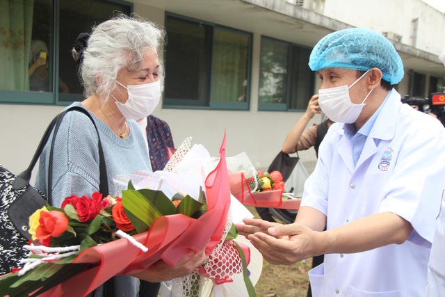 GS.TS. Phạm Như Hiệp, Giám đốc Bệnh viện Trung ương Huế trao hoa và chúc mừng bệnh nhân nghi nhiễm Covid-19 có kết quả âm tính sau 14 ngày cách ly 
