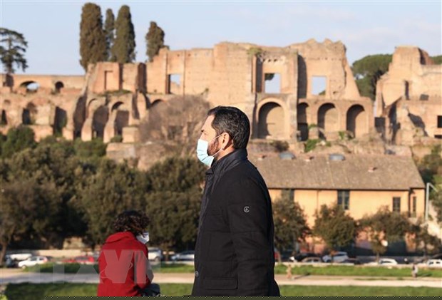 Người dân đeo khẩu trang phòng dịch COVID-19 khi di chuyển trên đường phố Rome, Italy. (Ảnh: THX/TTXVN)