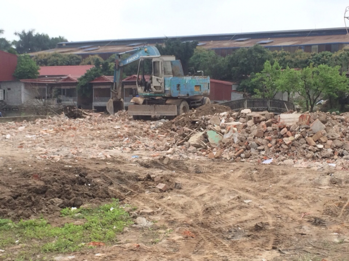 Máy xúc san gạt vôi thầu, gạch vữa trên đất nông nghiệp