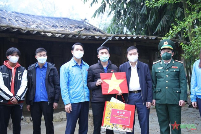 Cờ Tổ quốc được trao tặng c&aacute;c gia đ&igrave;nh đang sinh sống dọc tuyến đường bi&ecirc;n giới.