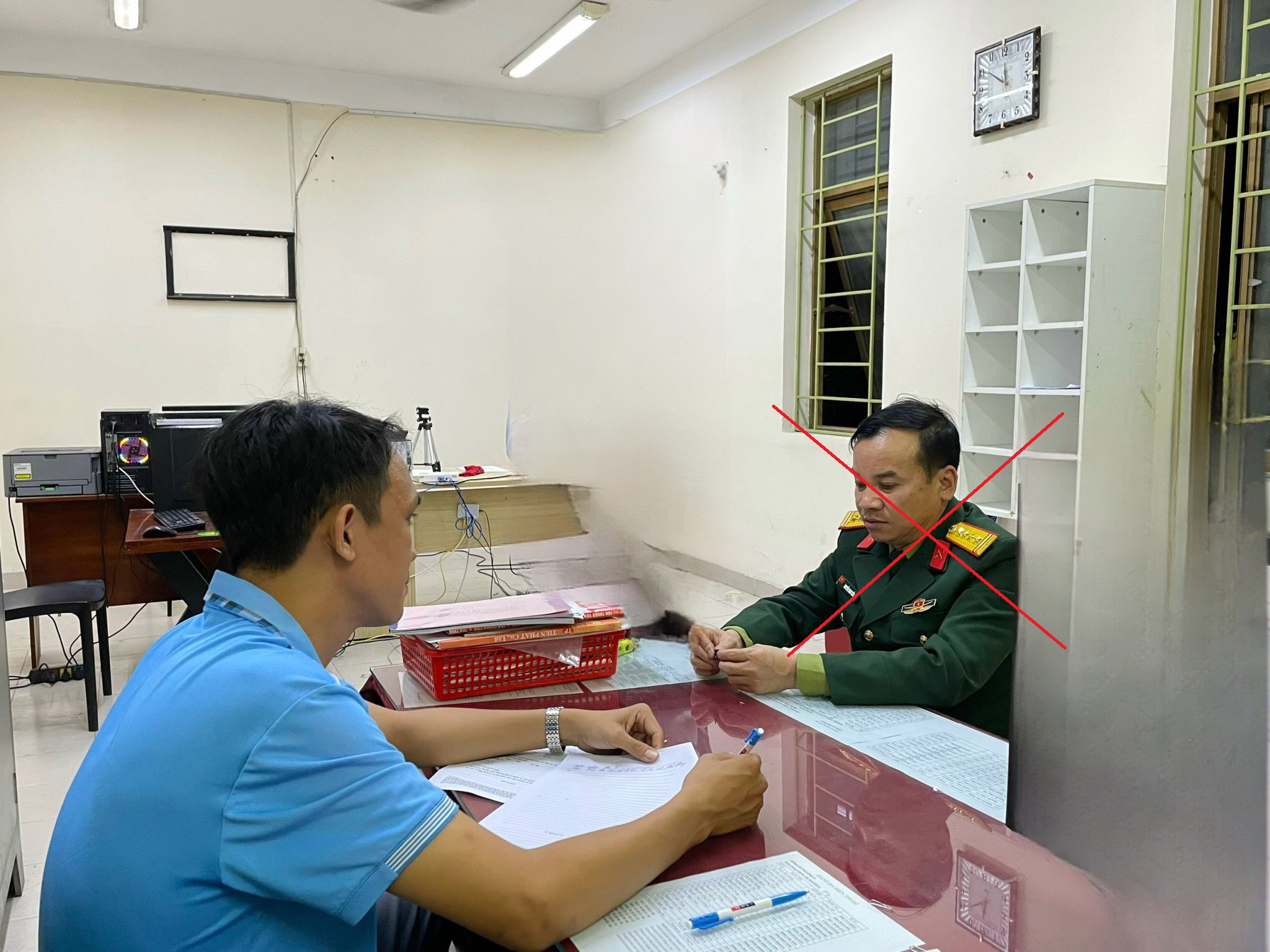 Đối tượng Nguyễn Nam Tiến (mặc quân phục, mang quân hàm Đại tá) bị tạm giữ tại cơ quan Công an