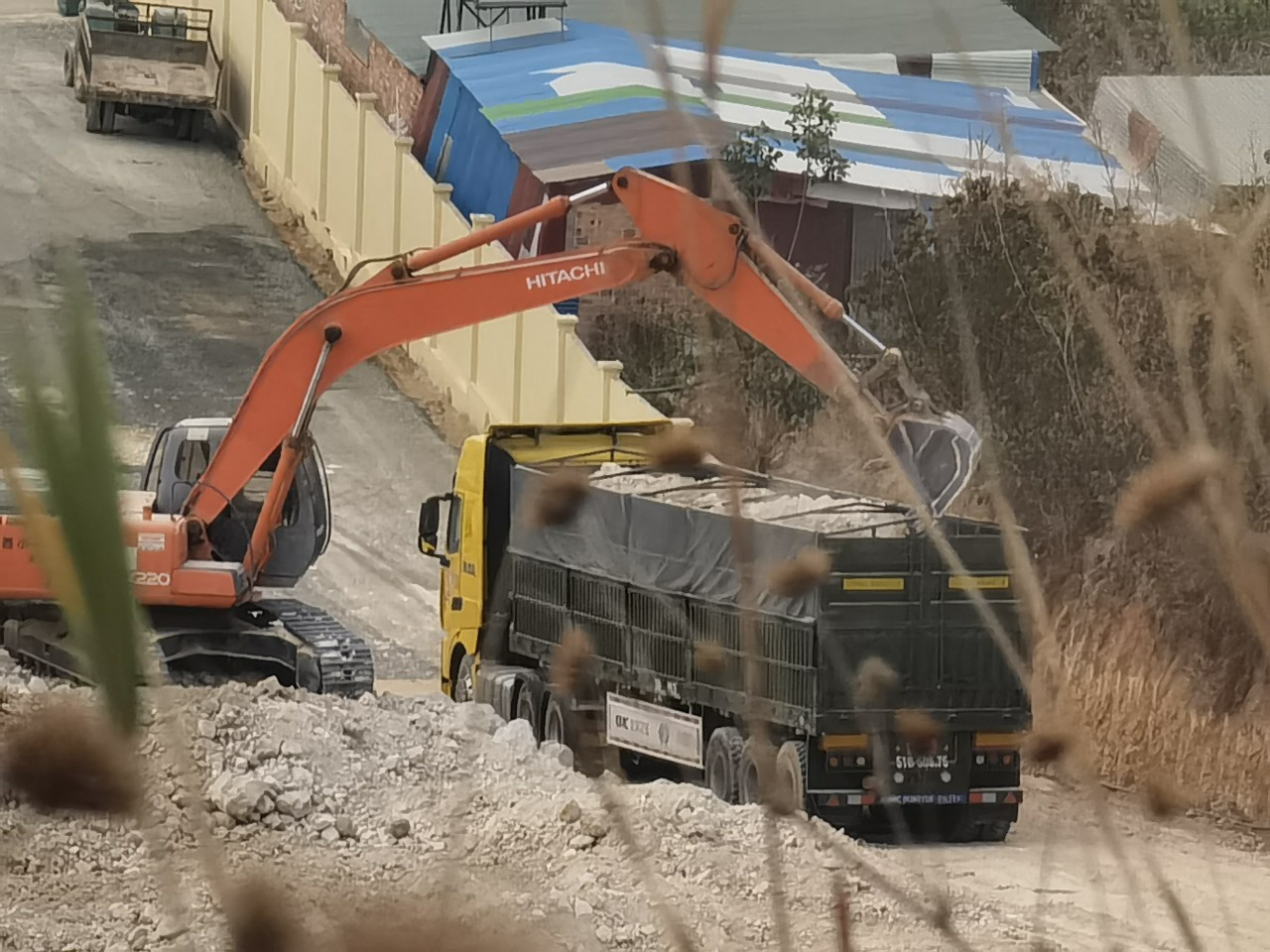 Chiếc xe đầu kéo được xe múc chất đầy đất sét từ trong khuôn viên Công ty Cổ phần đầu tư phát triển Lâm Hà 68