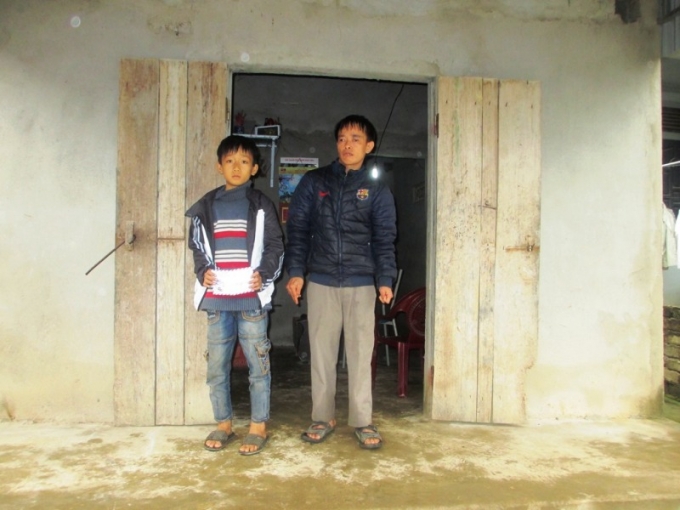 Hai cha con anh Dương trước căn nh&agrave; được ch&iacute;nh quyền địa phương v&agrave; anh em l&agrave;m cho.