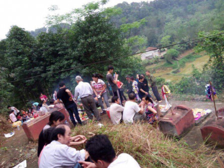 Nhiều gia đ&igrave;nh b&agrave;y m&acirc;m c&uacute;ng b&ecirc;n những ng&ocirc;i mộ của người th&acirc;n đ&atilde; khuất. (Ảnh: Người đưa tin)