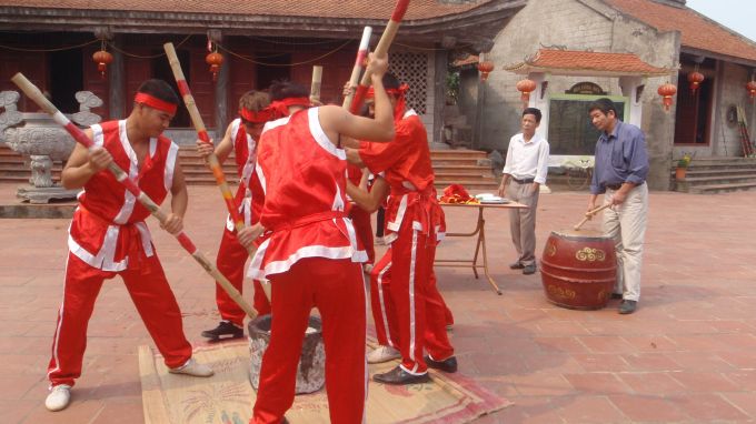 Sau khi cơm được đổ xuống cối đ&aacute;, 5 thanh ni&ecirc;n h&ograve; nhau gi&atilde;. 4 người gi&atilde; li&ecirc;n tục, người c&ograve;n lại cầm ch&agrave;y xoay giữa cối mục để bột được đều.