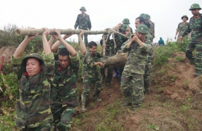 Lực lượng chức năng tiến h&agrave;nh đưa quả bom ra khỏi hiện trường.