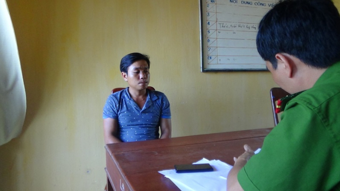 Đối tượng Tr&iacute; (&aacute;o xanh) tại trụ sở c&ocirc;ng an điều tra. Ảnh: CABS.