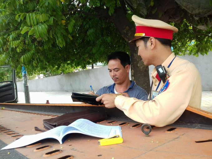 C&aacute;n bộ Đội CSGT số 6 đang tiến h&agrave;nh kiểm tra giấy tờ của l&aacute;i xe.