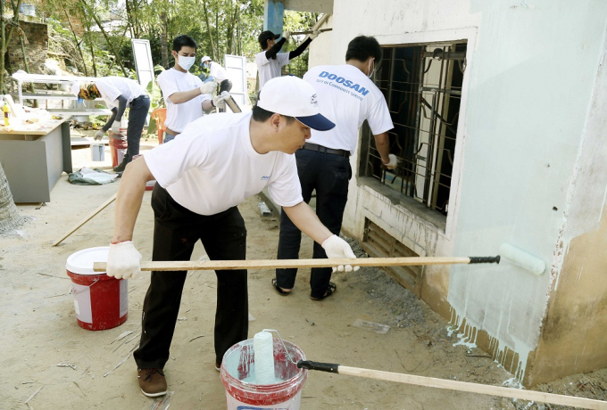 C&aacute;c t&igrave;nh nguyện vi&ecirc;n sơn lại căn nh&agrave; bị hư hỏng của người d&acirc;n tại Quảng Ng&atilde;i.