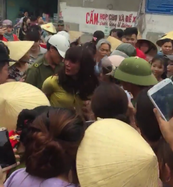 Nghi ngờ người phụ nữ th&ocirc;i mi&ecirc;n trộm t&agrave;i sản n&ecirc;n h&agrave;ng trăm người d&acirc;n đ&atilde; v&acirc;y lại giao nộp cho c&ocirc;ng an.