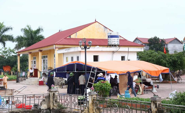 Đo&agrave;n c&ocirc;ng t&aacute;c&nbsp;ngồi trong l&aacute;n dựng trước nh&agrave; văn h&oacute;a th&ocirc;n. Ảnh Vnexpress.net