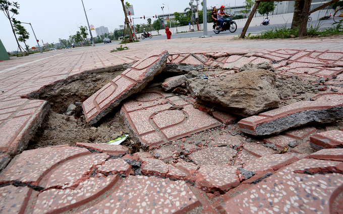 Vỉa h&egrave; tuyến phố rộng từ 5 đến 12 m, đ&atilde; được kẻ vạch sơn, 1/3 diện t&iacute;ch l&agrave; nơi để xe m&aacute;y.  Một đoạn vỉa h&egrave; bị sụt l&uacute;n với diện t&iacute;ch hơn một m2, khiến những miếng gạch l&aacute;t bị vỡ.