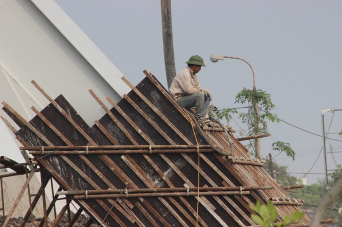 Cận cảnh c&aacute;c c&ocirc;ng nh&acirc;n đang bọc b&ecirc; t&ocirc;ng cho c&aacute;c trụ sắt khổng lồ.