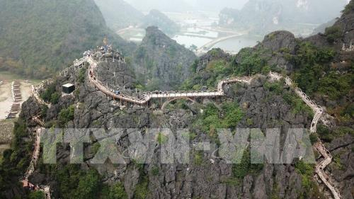 Kh&ocirc;ng chỉ l&agrave;m những bậc, lan can cầu thang, doanh nghiệp n&agrave;y c&ograve;n x&acirc;y dựng một chiếc cầu ki&ecirc;n cố bắc từ đỉnh n&uacute;i n&agrave;y qua đỉnh n&uacute;i kh&aacute;c để l&agrave;m đường đi cho kh&aacute;ch. Ảnh: Minh Đức - TTXVN