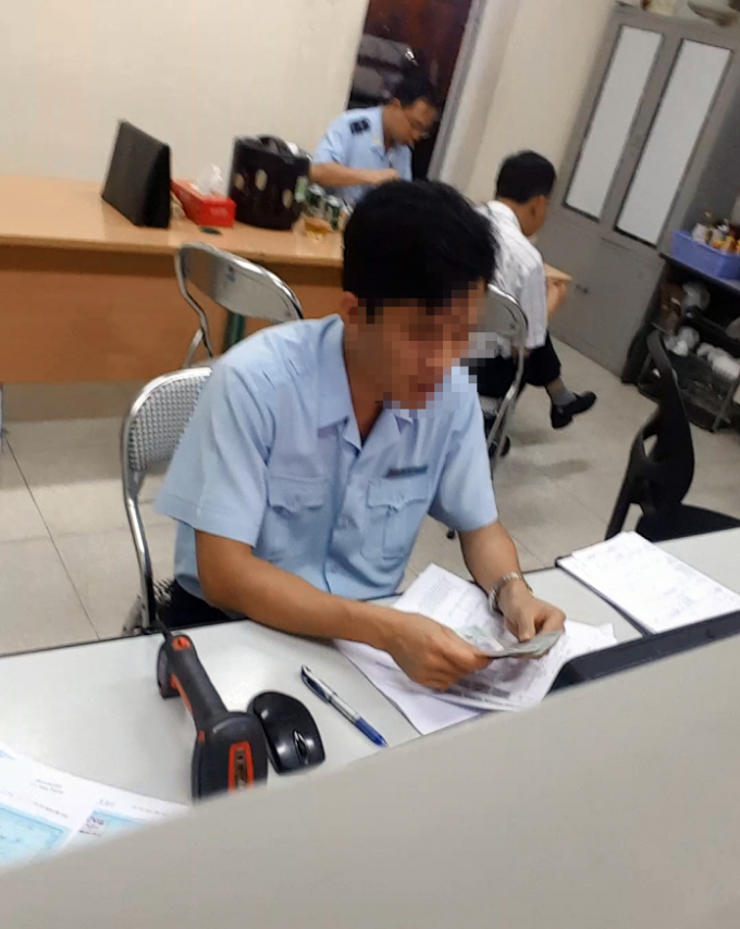 Một nh&acirc;n vi&ecirc;n hải quan đang kiểm tra số tiền h&agrave;ng triệu đồng vừa được nh&acirc;n vi&ecirc;n &ldquo;chạy lệnh&rdquo; nhanh ch&oacute;ng đưa v&agrave;o.