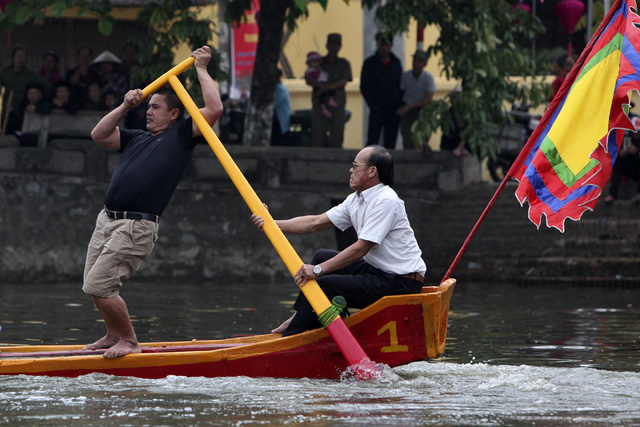 Trong ảnh l&agrave; người l&aacute;i ph&iacute;a sau thuyền.