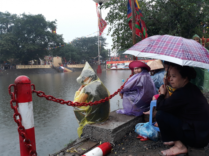 Nhiều người trung tuổi bất chấp trời mưa to vẫn đứng, ngồi dọc 2 b&ecirc;n kh&uacute;c s&ocirc;ng hồi hộp xem v&agrave; cổ vũ cuộc thi truyền thống của l&agrave;ng 5 năm mới tổ chức một lần.