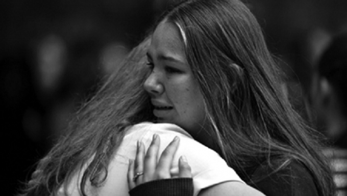 Hai c&ocirc; g&aacute;i an ủi nhau trong lễ cầu nguyện ở Christchurch ng&agrave;y 18/3.