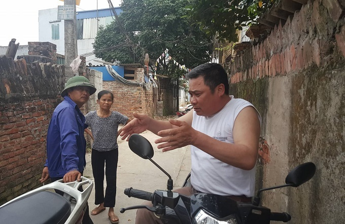 &Ocirc;ng Vương (&aacute;o trắng) v&agrave; một số người d&acirc;n đưa ph&oacute;ng vi&ecirc;n ra khu vực 'vườn quan' xưa kia