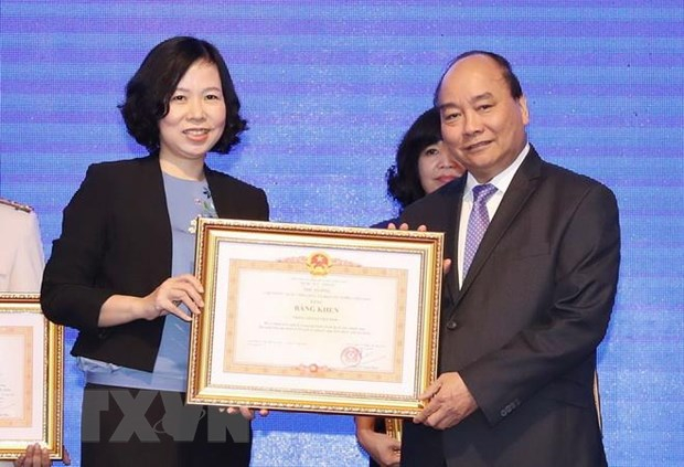 Thủ tướng Nguyễn Xu&acirc;n Ph&uacute;c trao tặng Bằng khen của Thủ tướng Ch&iacute;nh phủ cho Th&ocirc;ng tấn x&atilde; Việt Nam v&igrave; th&agrave;nh t&iacute;ch xuất sắc tại WEF ASEAN 2018. (Ảnh: Thống Nhất/TTXVN)