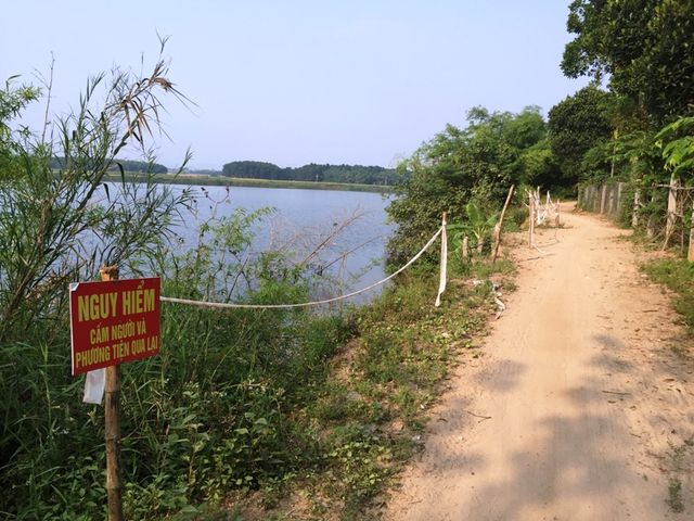 Người d&acirc;n cắm biển cảnh b&aacute;o b&ecirc;n bờ s&ocirc;ng để hạn chế người d&acirc;n qua lại.
