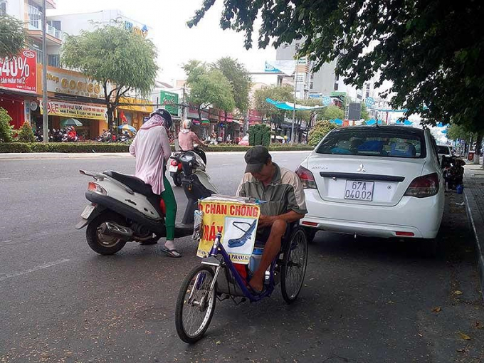 &Ocirc;ng Phan Văn Tuấn, 60 tuổi, người b&aacute;n v&eacute; số tại bến Ninh Kiều, trốn nắng dưới&nbsp;b&oacute;ng m&aacute;t h&agrave;ng c&acirc;y. Ảnh: CẨM GIANG