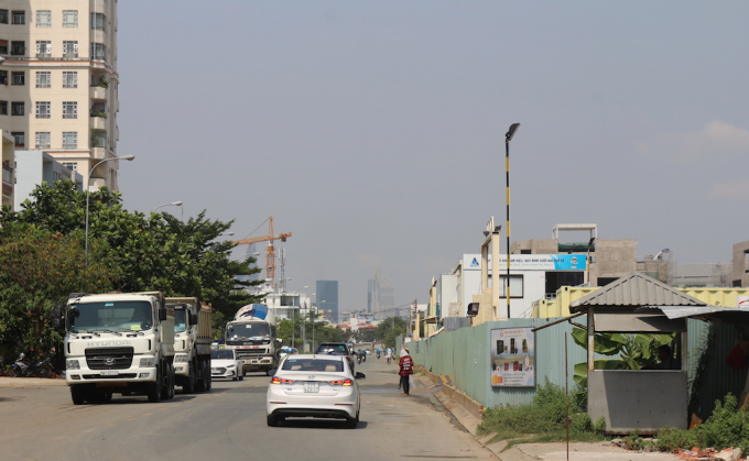 Trong khi dự &aacute;n lấn chiếm vỉa h&egrave; th&igrave; b&ecirc;n dưới l&ograve;ng đường, xe tải v&agrave; xe ben chở vật liệu thường xuy&ecirc;n ra v&agrave;o c&ocirc;ng trường.&nbsp;