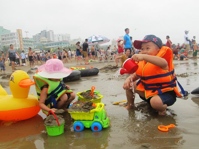 Nhằm đảm bảo an to&agrave;n cho du kh&aacute;ch, lực lượng cứu hộ, cứu nạn đ&atilde; phải đưa c&aacute;c ghế quan s&aacute;t ra biển (c&aacute;ch m&eacute;p nước khoảng 5 m) để đứng quan s&aacute;t v&agrave; li&ecirc;n tục nhắc nhở, d&ugrave;ng c&ograve;i cảnh b&aacute;o du kh&aacute;ch kh&ocirc;ng được bơi ra xa bờ khi tắm biển. Trong ảnh: Trẻ em vui chơi an to&agrave;n tr&ecirc;n c&aacute;c b&atilde;i biển Sầm Sơn.