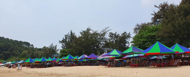 H&agrave;ng loạt ghế ngồi c&ugrave;ng những chiếc &ocirc; sặc sỡ, bắt mắt ngay tr&ecirc;n b&atilde;i c&aacute;t s&aacute;t biển nhưng kh&aacute;ch ngồi cũng chỉ l&aacute;c đ&aacute;c v&agrave;i người.