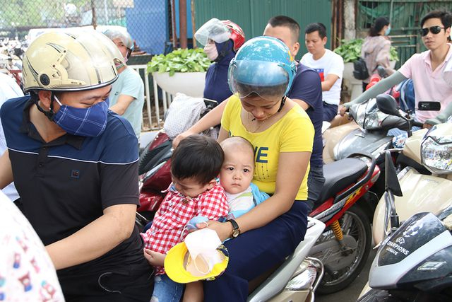 Một gia đ&igrave;nh cho con nhỏ v&agrave;o c&ocirc;ng vi&ecirc;n chơi, tuy nhi&ecirc;n để c&oacute; thể gửi được xe mua v&eacute; họ phải đợi nửa tiếng đồng hồ.