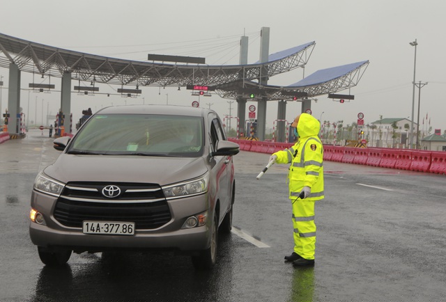 Lực lượng CSGT tiến hành ra tín hiệu dừng phương tiện để nhân viên y tế kiểm tra đo thân nhiệt tài xế và người ngồi trong ô tô.