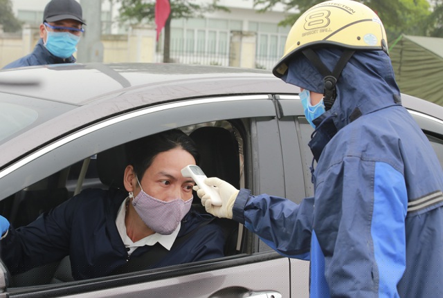 Các nhân viên y tế tiến hành kiểm tra thân nhiệt của toàn bộ người ngồi trên xe.