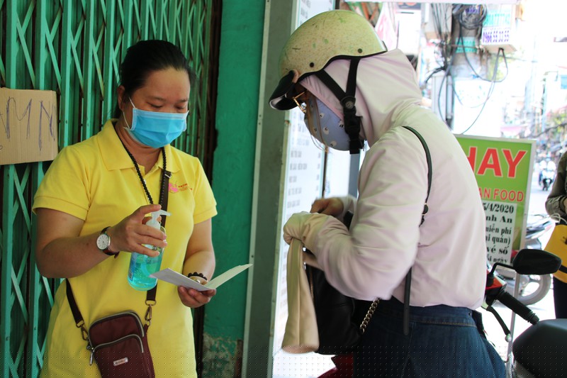 Chị Khánh Nhi trao số tiền mình và các bạn đóng góp hỗ trợ thêm suất ăn cho người lao động nghèo.
