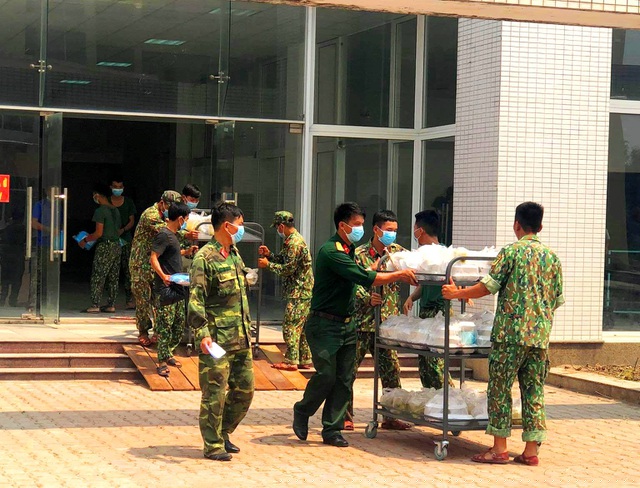 Các chiến sĩ bộ đội chuyển cơm tới từng phòng