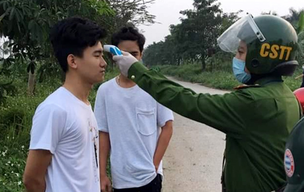 Tổ công tác liên ngành quận Bắc Từ Liêm tiến hành đo thân nhiệt và lập biên bản xử phạt một thanh niên ra đường không có lý do chính đáng.