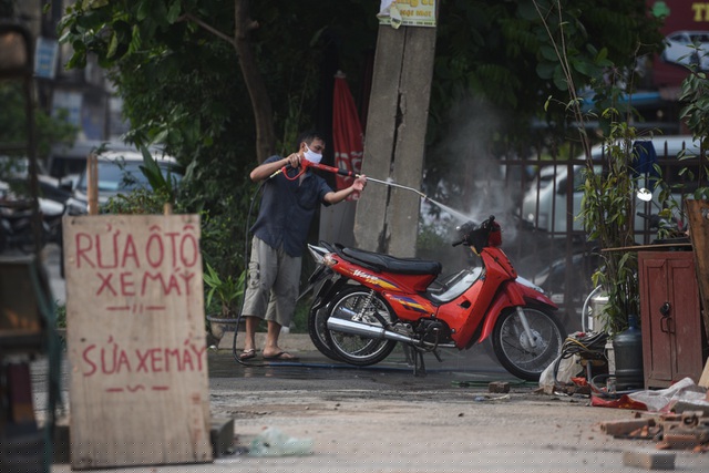 Một hàng rửa xe máy trên phố Minh Khai (quận Hai Bà Trưng).