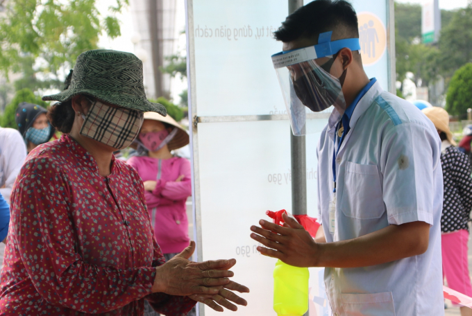 Trước khi vào nhận gạo, người dân được rửa tay sát khuẩn.