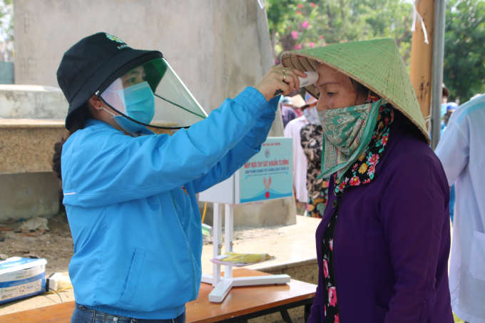 Đo thân nhiệt cho người dân.