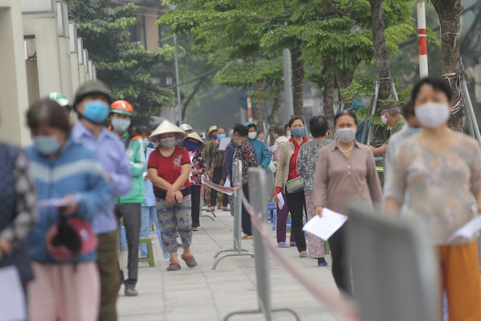 Hình ảnh hàng trăm người dân xếp hàng chờ nhận gạo miễn phí.