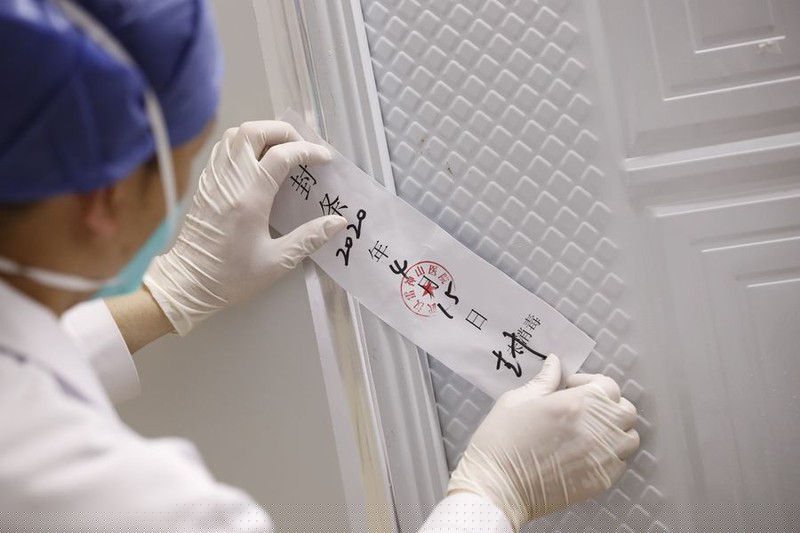 Một y tá niêm phong một cổng của Bệnh viện Lôi Thần Sơn ở Vũ Hán, Hồ Bắc, Trung Quốc, ngày 15/4/2020. Bệnh viện Lôi Thần Sơn ngừng hoạt động ngày 15/4/2020. Ảnh: Tân Hoa Xã. 