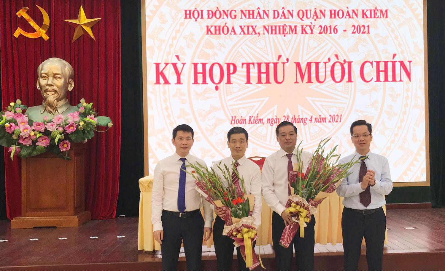 Bí thư Quận ủy Hoàn Kiếm Vũ Đăng Định (ngoài cùng bên phải), Chủ tịch UBND quận Hoàn Kiếm Phạm Tuấn Long (ngoài cùng bên trái) tặng hoa chúc mừng ông Đinh Hồng Phong và ông Nguyễn Quốc Hoàn