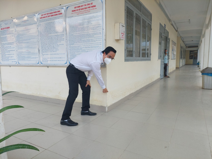 Thầy Phan Anh Tuyến chỉ vào dấu vạch nước ngập còn in lại trên tường.