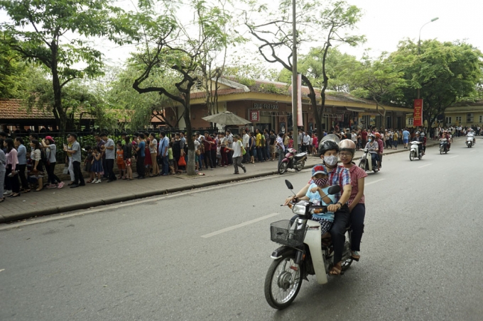 D&ograve;ng người xếp h&agrave;ng trật tự tr&ecirc;n vỉa h&egrave;, trong khi đ&oacute; ph&iacute;a dưới l&ograve;ng đường kh&aacute; vắng vẻ