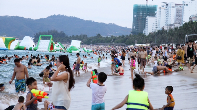 Lượng kh&aacute;ch tăng đột biến khiến b&atilde;i biển Nha Trang nằm s&aacute;t trục đường Trần Ph&uacute;, trung t&acirc;m th&agrave;nh phố d&agrave;i khoảg 4 km từ cầu Trần Ph&uacute; về c&ocirc;ng vi&ecirc;n Bạch Đằng đ&ocirc;ng nghẹt. Nhiều du kh&aacute;ch cho biết, kỳ nghỉ lễ k&eacute;o d&agrave;i n&ecirc;n họ đ&atilde; tận dụng thời gian đưa gia đ&igrave;nh đi du lịch.
