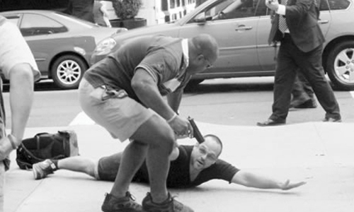 Ph&oacute;ng vi&ecirc;n ảnh nằm rạp xuống đất sau khi bị mật vụ mặc thường phục r&uacute;t s&uacute;ng khống chế (Ảnh:&nbsp;NYPost).