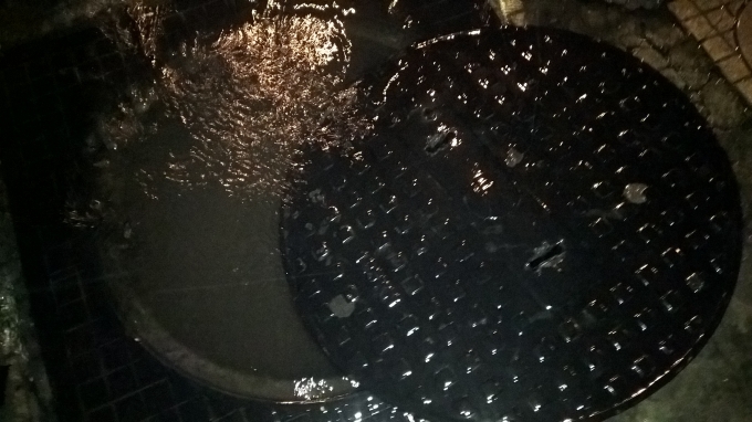 Nắp hố ga bị bật do sức nước từ cống đẩy l&ecirc;n.