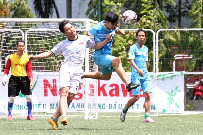 Cầu thủ L&ecirc; Ho&agrave;ng (&Aacute;o xanh) của Li&ecirc;n qu&acirc;n B&aacute;o Thể thao trong 1 pha tranh chấp.